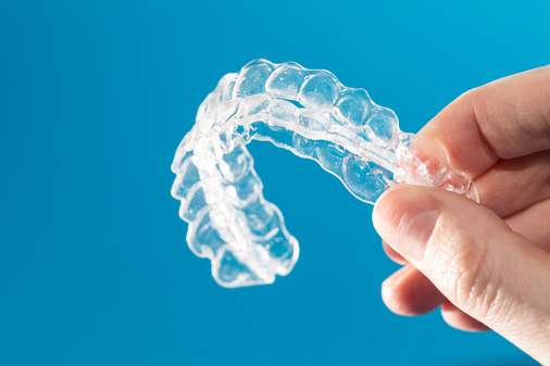 Image of a person holding invisalign at East Village Dental Centre.