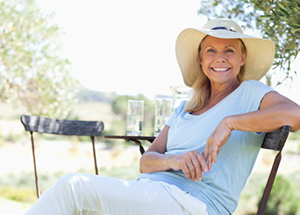 Older woman smiling outdoors while camping