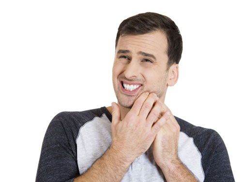 man holding face in pain because of mouth sores